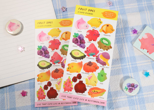 A sticker sheet with various designs of cute dogs dressed in fruit outfits, designed by Reytorra. Use them for planners, decorating, and journals.