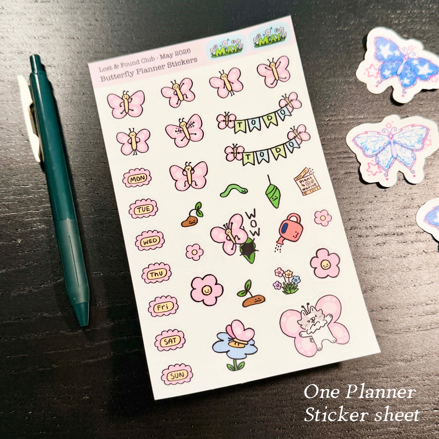 Butterfly planner stickers sheet with a pen on a dark surface