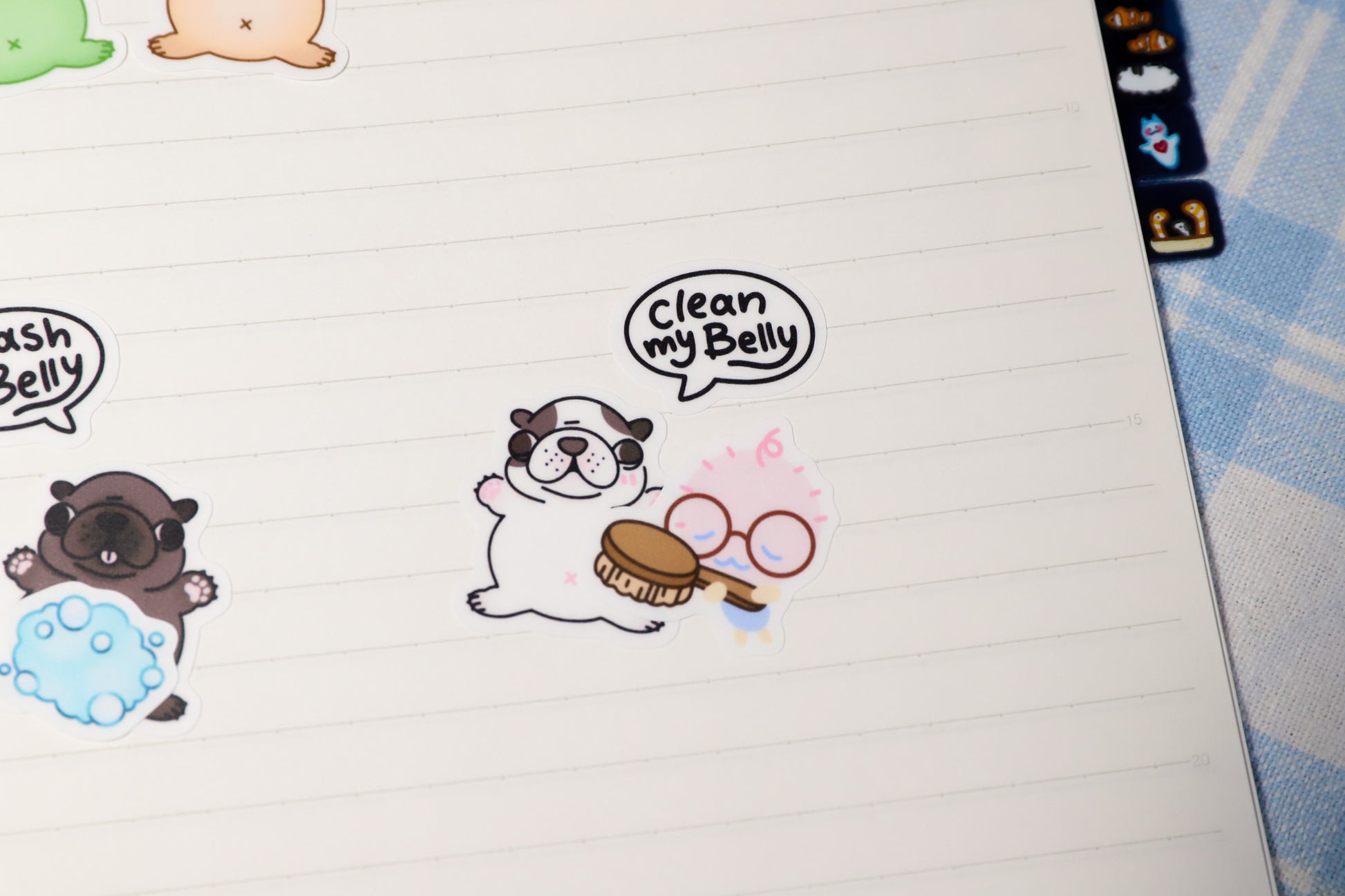 Cartoon dog gmail stickers on a notebook with speech bubbles saying clean my belly and a blue border.