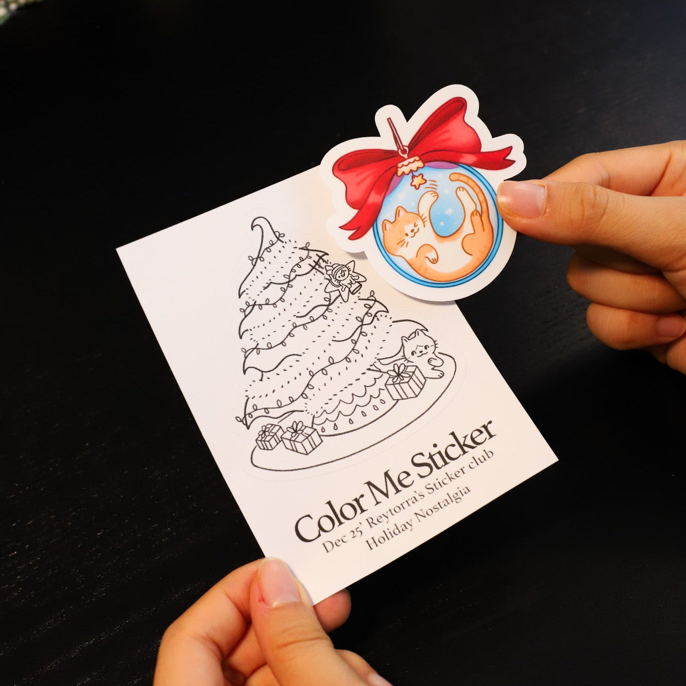 Coloring book with a sticker of a cake and a hand holding it.