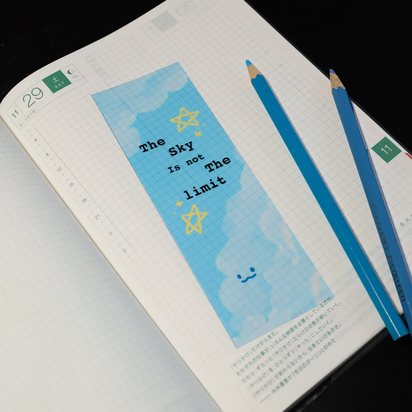 Book with a cloud themed bookmark with a quote saying the sky is not the limit